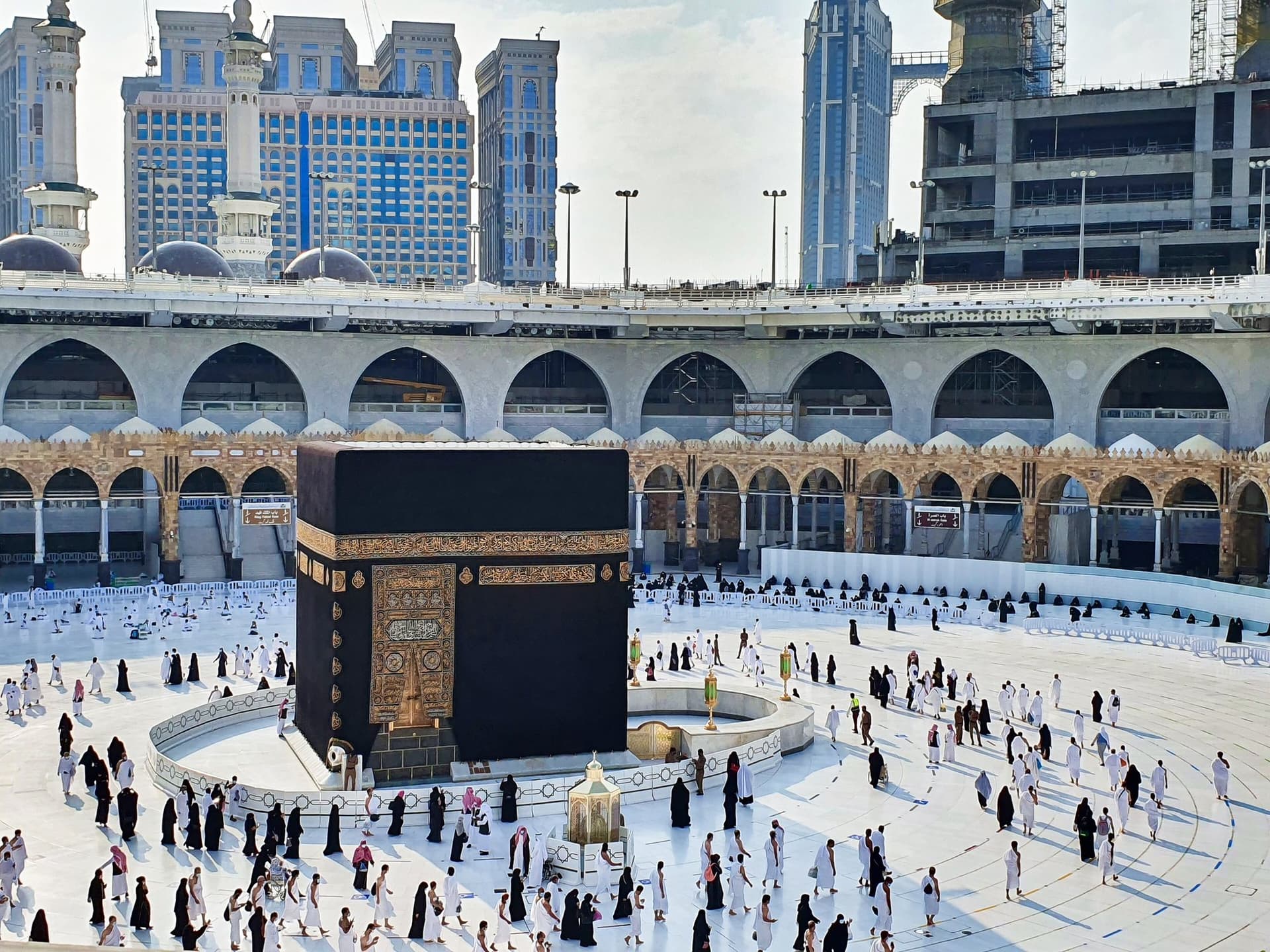 Gündüz vakti Mescid-i Haram'ın beyaz mermer metafında Kâbe-i Muazzama ve tavaf eden ziyaretçiler